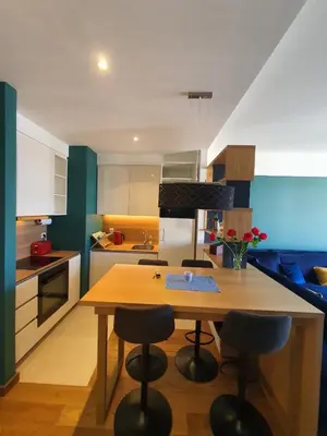 a kitchen with a wooden table and some chairs at AparTwentyOne - Your Home in Belgrade in Belgrade