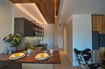 a kitchen with a wooden table with two plates on it at STUDIO K district (central BG+private parking) in Belgrade
