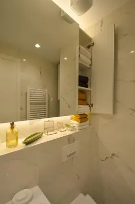 a white bathroom with a toilet and a mirror at STUDIO K district (central BG+private parking) in Belgrade