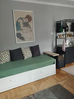 a bedroom with a large white bed with a green blanket at Apartman Aleksandra in Smederevo