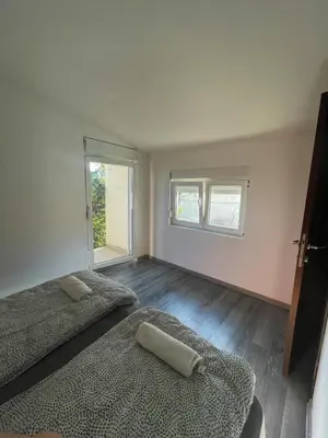 a bedroom with two beds and two windows at Vracar Apartment in Belgrade