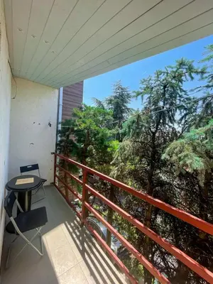 a balcony with a table and chairs and trees at Vracar Apartment in Belgrade