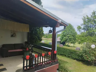 a porch with a couch and a fence with red candles at KosMaj Dan Belgrade, Sopot in Belgrade
