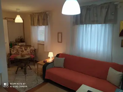 a living room with a red couch and a table at KosMaj Dan Belgrade, Sopot in Belgrade