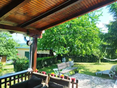 a patio with two benches under a wooden pergola at KosMaj Dan Belgrade, Sopot in Belgrade