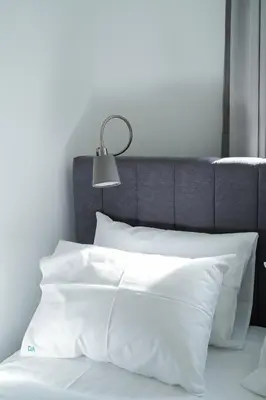 a bed with white pillows and a lamp at Quiet Luxury Family Apt Belgrade Fortress Center in Belgrade