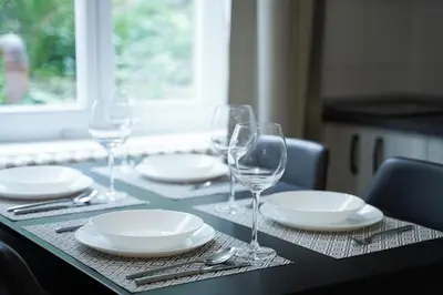 a table with plates and wine glasses on it at Quiet Luxury Family Apt Belgrade Fortress Center in Belgrade
