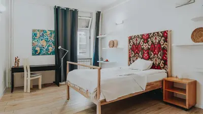 a bedroom with a bed and a table and a window at BGLAB Salon Apartment in Belgrade
