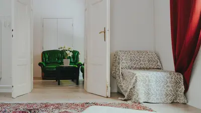 a living room with a chair and a green chair at BGLAB Salon Apartment in Belgrade