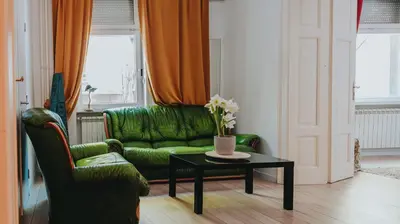a living room with a green couch and a table at BGLAB Salon Apartment in Belgrade