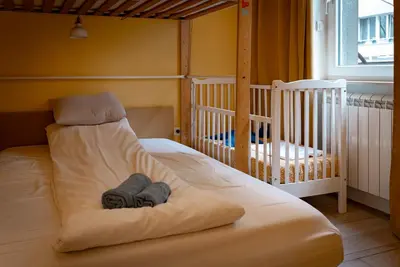 a bed in a room with a crib at BGLAB Salon Apartment in Belgrade