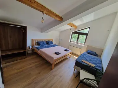 a large bedroom with a bed and a window at Che Private Rooms Banovci in Novi Banovci