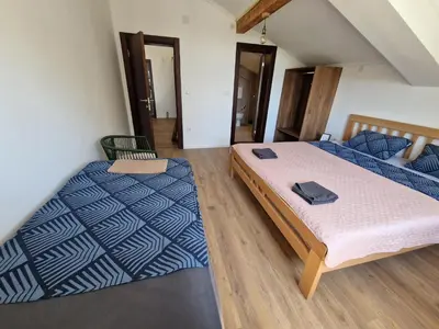 two beds in a room with blue and white sheets at Che Private Rooms Banovci in Novi Banovci