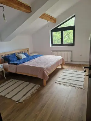a bedroom with a bed and a large window at Che Private Rooms Banovci in Novi Banovci