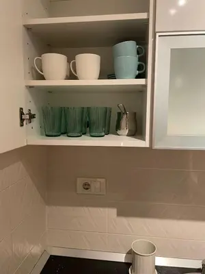 a cupboard with green bowls and plates on it at New Sky Terrace in Belgrade