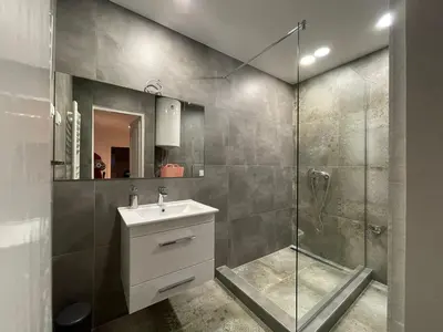 a bathroom with a shower and a sink and a mirror at New Sky Terrace in Belgrade
