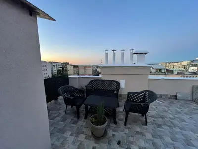 a patio with chairs and tables on a rooftop at New Sky Terrace in Belgrade