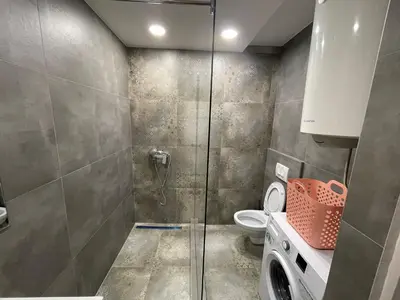 a bathroom with a shower and a washing machine at New Sky Terrace in Belgrade