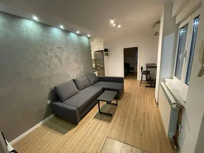 a living room with a couch and a wall at New Sky Terrace in Belgrade