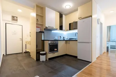 a kitchen with white cabinets and a counter top at President Apartman 8 in Vračar (historical)