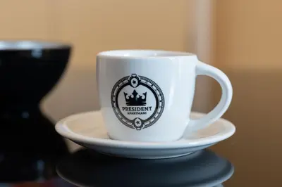 a coffee cup sitting on a plate on a table at President Apartman 8 in Vračar (historical)