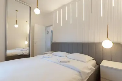 a bedroom with a white bed with two towels on it at President Apartman 8 in Vračar (historical)