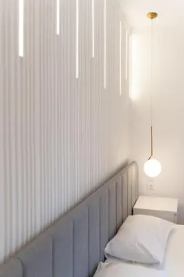 a bedroom with a bed and a white wall at President Apartman 8 in Vračar (historical)