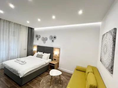 a bedroom with a bed and a yellow couch at MONI Downtown Luxury Apartments in Belgrade