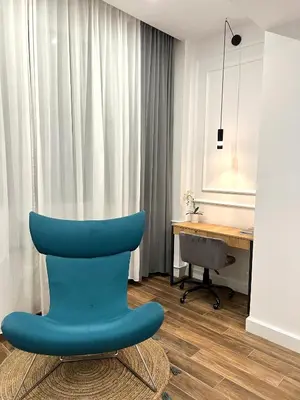 a blue chair sitting in a room with a desk at MONI Downtown Luxury Apartments in Belgrade