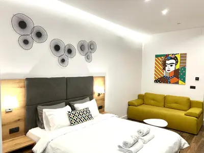 a bedroom with a bed and a green couch at MONI Downtown Luxury Apartments in Belgrade