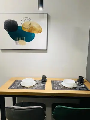 a table with two plates and a picture on the wall at MONI Downtown Luxury Apartments in Belgrade