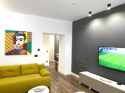 a living room with a yellow couch and a flat screen tv at MONI Downtown Luxury Apartments in Belgrade