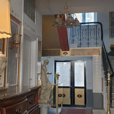 a staircase with a statue of a woman on a stand in a room at VANSVEL Boutique Apartment 8 in Belgrade