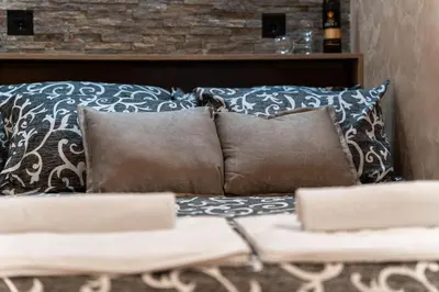 a couch with pillows and a table with pillows at Apartments Wolf in Belgrade