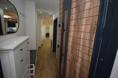 a bathroom with a wooden door and a mirror at Apartments Wolf in Belgrade