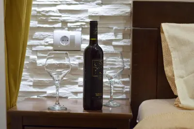 a bottle of wine and two wine glasses on a table at Apartments Wolf in Belgrade
