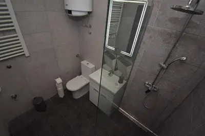 a bathroom with a toilet and a shower with a glass door at Apartments Wolf in Belgrade