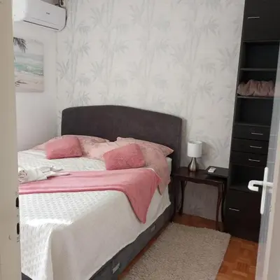 a bedroom with a bed with pink pillows on it at Apartment MrC , FREE PARKING in Bežanija