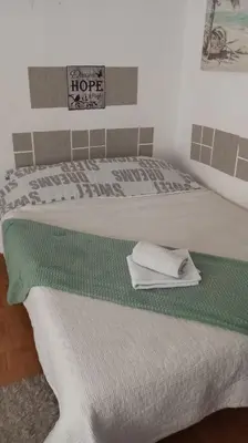 two beds in a room with a green and white blanket at Apartment MrC , FREE PARKING in Bežanija