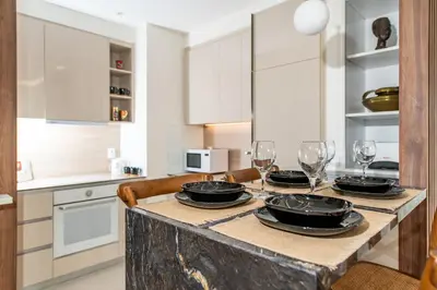 a kitchen with a table with plates and wine glasses at Belgrade Waterfront Bramar in Belgrade