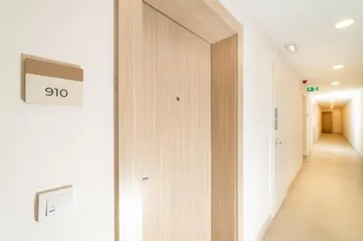 a hallway with a door with a clock on it at Belgrade Waterfront Bramar in Belgrade