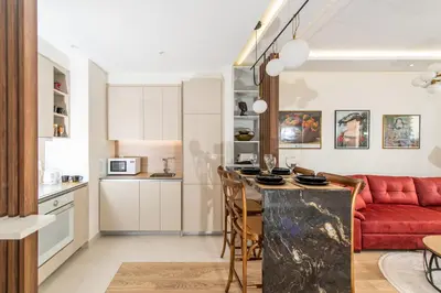 a kitchen and a living room with a red couch at Belgrade Waterfront Bramar in Belgrade
