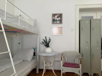 a bedroom with a bunk bed and a table and a chair at Hostel Beogradjanka in Belgrade