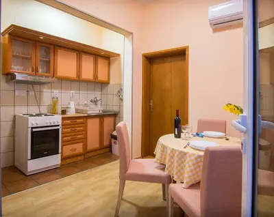 a kitchen with a table and chairs and a kitchen with a stove at Sasa's House in Belgrade