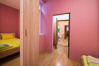 a bedroom with pink walls and a bed and a mirror at Sasa's House in Belgrade