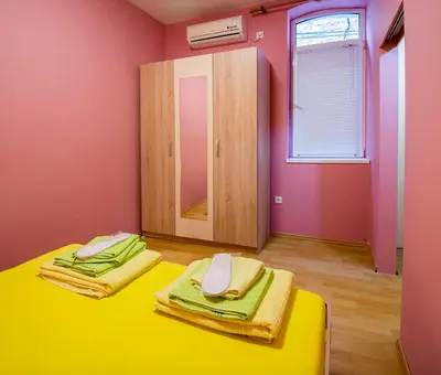 a room with a yellow table and a mirror at Sasa's House in Belgrade