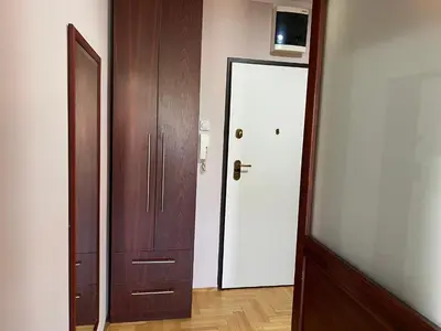 a hallway with a white door and a wooden cabinet at Hill Apartment in Belgrade