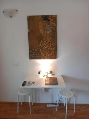 a desk with two stools and a painting on the wall at Cosy Rooftop studio with balcony in Belgrade
