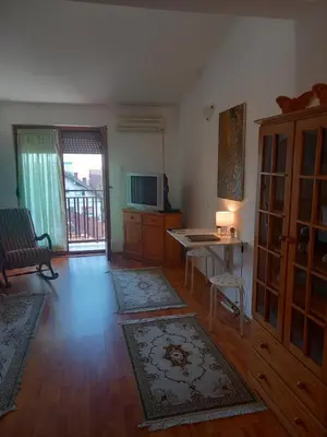 a living room with a television and a table and a desk at Cosy Rooftop studio with balcony in Belgrade