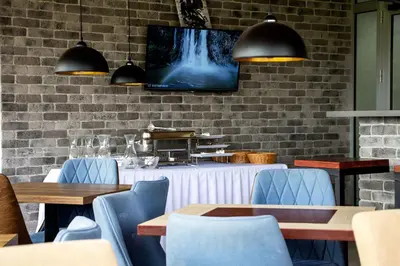 a restaurant with tables and chairs and a tv on a brick wall at ELEVENROOMS in Belgrade